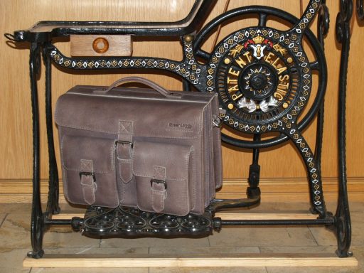 GREENLAND Braune Aktentasche auf einem historischen Nähmaschinenständer.